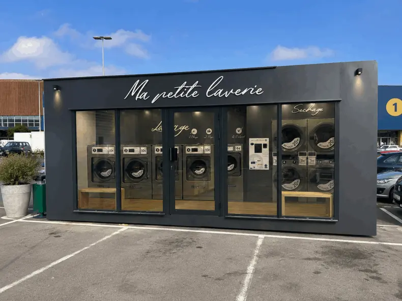 Bungalow laverie automatique installé sur un parking